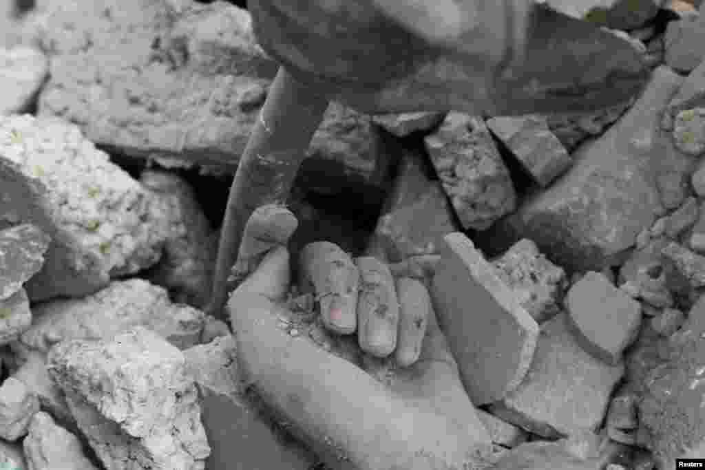 The hand of a Palestinian killed in Israeli strikes lies under the rubble in Khan Younis in the southern Gaza Strip.