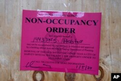 A City of Harvey, Ill., No-Occupancy Order is taped on plywood at an apartment in a courtyard-style complex, Jan. 8, 2024, in Harvey. Some residents were boarded up inside and outside late last week.