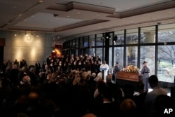 Pastor Tony Lowden speaks as a Georgia State Patrol honor guard stands at the casket of former first lady Rosalynn Carter during a repose service at the Jimmy Carter Presidential Library and Museum in Atlanta, Nov. 27, 2023.