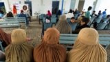 FILE - Afghan female refugees living in Pakistan wait to get registered at an office in Peshawar, Pakistan, Sept. 30, 2021. Pakistan confirmed Sept. 28, 2023, that all foreign nationals living unlawfully in the country would be forced out.