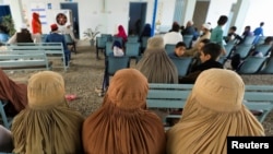 FILE - Afghan women refugees living in Pakistan wait to get registered at an office in Peshawar, Pakistan, Sept. 30, 2021.