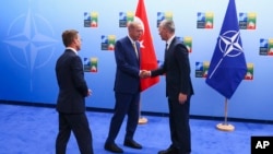 Turkish President Recep Tayyip Erdogan, center, shakes hands with NATO Secretary General Jens Stoltenberg, right, as Sweden's Prime Minister Ulf Kristersson, left, looks on ahead of a NATO summit in Vilnius, Lithuania, July 10, 2023.