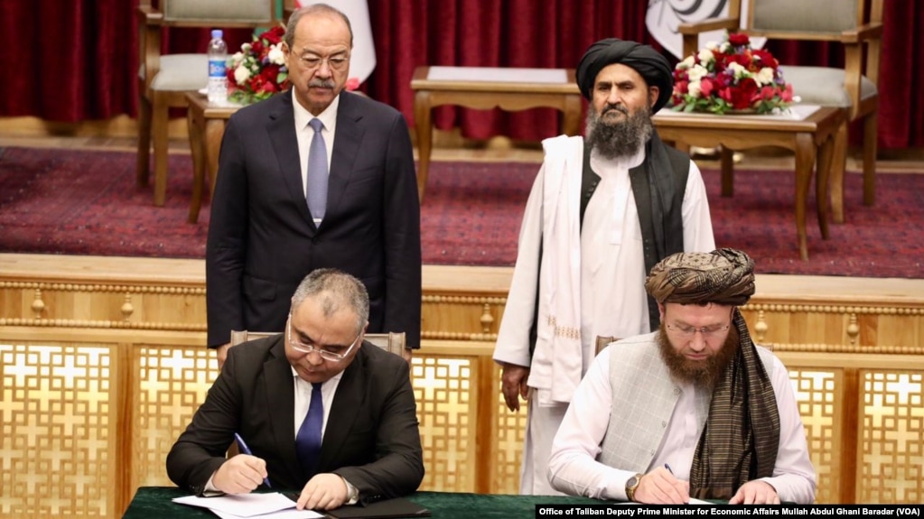 Uzbek Prime Minister Abdulla Aripov, back row, left, and Taliban Deputy Prime Minister for Economic Affairs Mullah Abdul Ghani Baradar, back row, right, oversee the signing of Memorandums of Understanding in Kabul, Afghanistan, Aug. 17, 2024. 