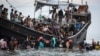 Pengungsi Rohingya yang baru tiba kembali ke perahu setelah masyarakat setempat memutuskan untuk mengizinkan mereka mendarat sementara untuk mendapatkan air dan makanan di Ulee Madon, provinsi Aceh, 16 November 2023. (Amanda Jufrian / AFP)