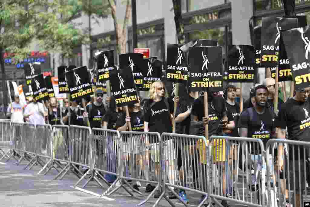 Picketers carry signs outside NBC in Rockefeller Center in New York. The actors strike comes more than two months after screenwriters began striking in their bid to get better pay and working conditions and have clear guidelines around the use of AI in film and television productions.