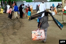 Sudanese displaced from the town of Sinjah receive humanitarian aid at their makeshift camp in the eastern city of Gedaref, Aug. 22, 2024.