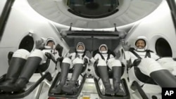 In this image taken from video broadcast by SpaceX, crew members wave after the SpaceX Dragon capsule splashed down into the Gulf of Mexico, just off the Florida Panhandle, May 30, 2023. (SpaceX via AP)