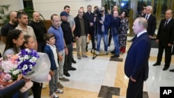 FILE - Russian President Vladimir Putin, right, speaks to released Russian prisoners upon their arrival at Vnukovo government airport outside Moscow, Aug. 1, 2024. (Kremlin pool photo via AP)