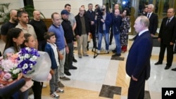 Russian President Vladimir Putin, right, speaks to released Russian prisoners upon their arrival at the Vnukovo government airport outside Moscow, Aug. 1, 2024. (Kremlin pool photo via AP)