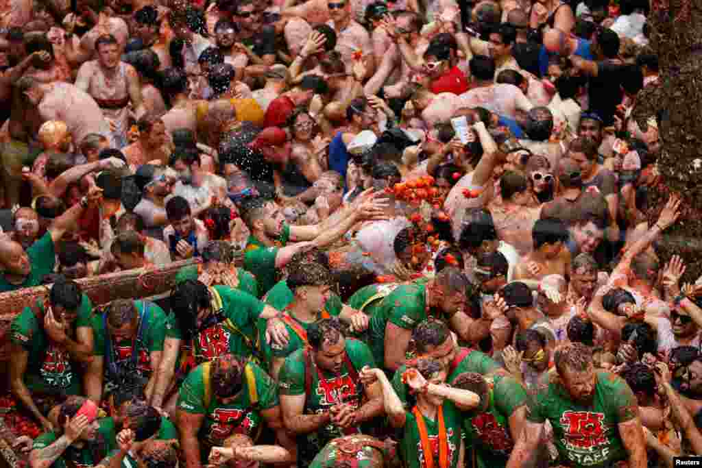 Foliões atiram tomates uns aos outros durante o festival de luta de comida &ldquo;La Tomatina&rdquo; em Bunol, perto de Valência, Espanha, a 28 de agosto de 2024.