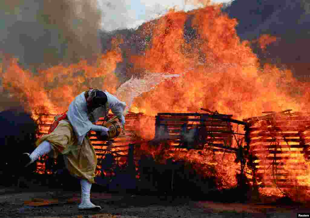 A Buddhist monk splashes water on a bonfire at the fire-walking&nbsp;festival, called Hiwatari Matsuri in&nbsp;Japanese, at Mt. Takao in Tokyo.