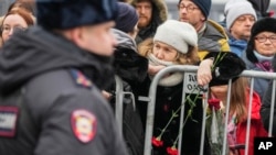 A police officer guards as people gather near the Church of the Icon of the Mother of God Soothe My Sorrows, in Moscow, March 1, 2024.