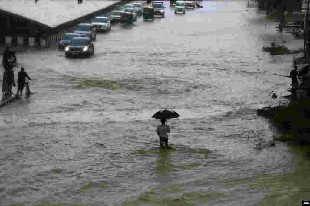 People commute through a waterlogged road after heavy rainfall in Gurgaon, India.