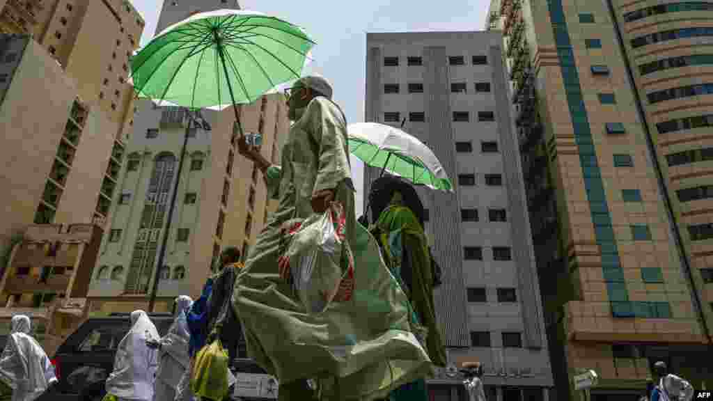 Muslim pilgrims use umbrellas to protect themselves from the sun as they walk in the holy city of Mecca.