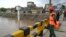Rescue workers monitor the flood situation at a bridge over a stream in Rawalpindi, Pakistan, on July 7, 2023. 