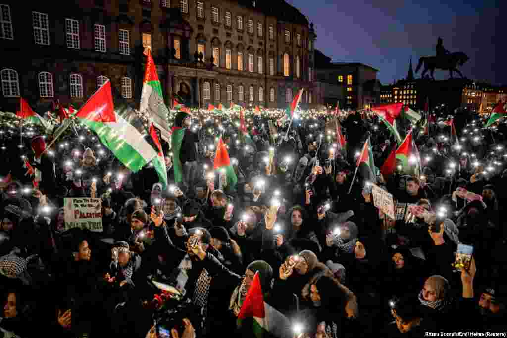 People light up their phones as they participate in a pro-Palestinian rally in front of the Danish parliament Christiansborg in central Copenhagen, Denmark.