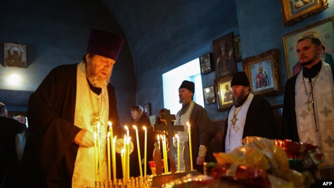 A church service is held for those killed in the Russian Il-76 military transport plane crash in the Belgorod region, in the village of Yablonovo near the crash site, on Jan. 24, 2024.