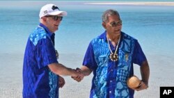 Perdana Menteri Australia Anthony Albanese, kiri, dan Perdana Menteri Tuvalu Kausea berjabat tangan di One Foot Island setelah menghadiri Leaders' Retreat selama Forum Kepulauan Pasifik di Aitutaki, Kepulauan Cook, 9 November 2023. (Foto: via AP)