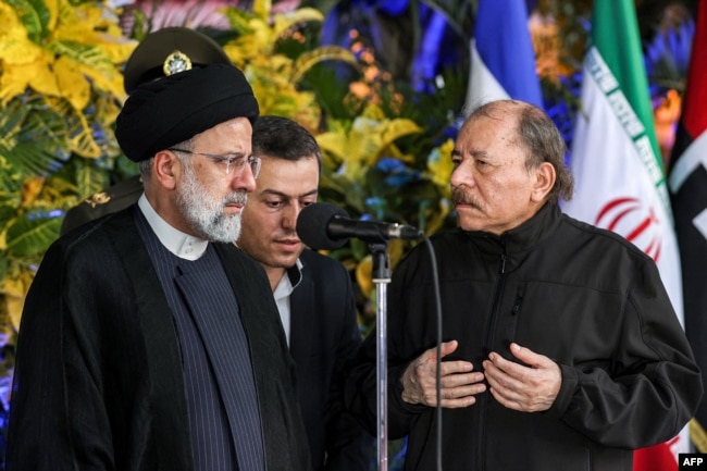This handout picture provided by the Iranian presidency shows Nicaragua's President Daniel Ortega, right, welcoming Iran's President Ebrahim Raisi at the Olof Palme Convention Centre in Managua on June 13, 2023. (Photo by Iranian Presidency/AFP)