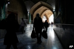 People walk through the corridor of the Imam Mosque in Tehran, Iran, March 2, 2024.