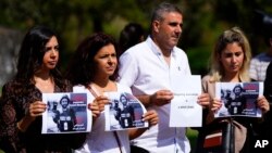 FILE - Lebanese journalists hold portraits of Reuters videographer Issam Abdallah, who was killed by Israeli shelling, during a protest in front of the United Nations headquarters in Beirut, Oct. 15, 2023.