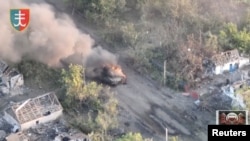 A tank burns as Ukrainian Armed Forces members liberate the town of Staromaiorske, in the Donestk region, Ukraine, in this still image obtained from video social media and released July 27, 2023. (35th Separate Marines Brigade of the Ukrainian Armed Forces/via Reuters)