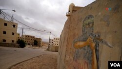 Grafiti de un miliciano palestino en un muro de Little Gaza, una réplica casi real de una ciudad árabe, donde entrenan soldados israelíes, el 27 de noviembre de 2023.