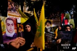 Hezbollah supporters hold Hezbollah flags and portraits of Hezbollah leader Sayyed Hassan Nasrallah during a protest in solidarity with the Palestinian people in Gaza, in the southern suburb of Beirut, Lebanon, Oct. 18, 2023.