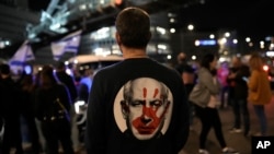 A protester, wearing a shirt with an image of Israeli Prime Minister Benjamin Netanyahu covered with a bloody hand print — stands at a rally in Tel Aviv, Israel, Jan. 20, 2024, demanding the release of hostages kidnapped on Oct. 7 by Hamas militants.