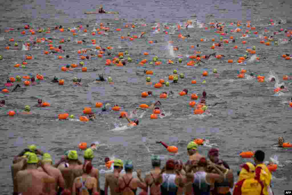 Participants take part in the Harbour Race, where swimmers cross Hong Kong&#39;s Victoria Harbour, in the city.