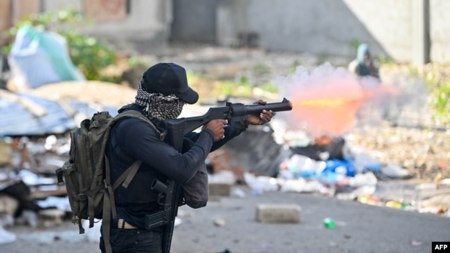 FILE - A policeman shoots tear gas at protesters during a demonstration calling for the resignation of Prime Minister Ariel Henry in Port-au-Prince on Feb. 7, 2024. Special police units were deployed across the city on Feb. 29, 2024, as violence swept through the area.