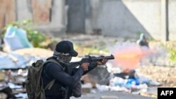 FILE - A policeman shoots tear gas at protesters during a demonstration calling for the resignation of Prime Minister Ariel Henry in Port-au-Prince on February 7, 2024.