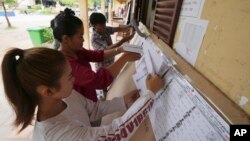 Locals look at a registration list before voting at a polling station on the outskirts of Phnom Penh, Cambodia, July 22, 2023. 