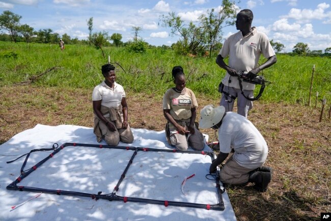 Deminers from the Mines Advisory Group (MAG) prepare to do clearance at a site containing cluster munitions in Ayii, Eastern Equatoria state, in South Sudan Thursday, May 11, 2023. (AP Photo/Sam Mednick)