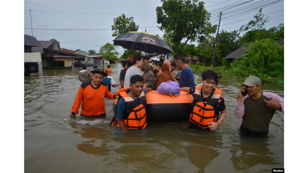 Petugas Badan Penanggulangan Bencana Daerah (BPBD) menggunakan perahu karet untuk mengevakuasi warga di kawasan pemukiman yang terkena dampak banjir akibat hujan lebat, di Padang, provinsi Sumatera Barat, 8 Maret 2024. (Antara Foto/Iggoy el Fitra/ via REUTERS)