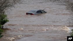 An abandoned car in a mall parking lot sits in floodwaters following a major rain event in Halifax, Nova Scotia, Canada, July 22, 2023.