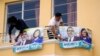 Seed Movement backers place banners with photos of their presidential candidate Bernardo Arevalo and running mate Karin Herrera at his office in Guatemala City, July 13, 2023. A court granted an injunction Thursday to block the suspension of the party.