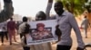 Des Nigériens participent à une marche appelée par des partisans du chef du coup d'État, le général Abdourahmane Tchiani, photographié, à Niamey, au Niger, le 30 juillet 2023.