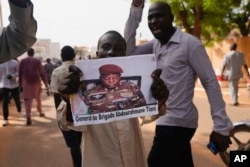Nigeriens participate in a march called by supporters of coup leader Gen. Abdourahmane Tchiani, pictured, in Niamey, Niger, July 30, 2023.