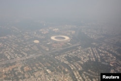 Foto udara menampilkan bangunan tempat tinggal dan stadion berselimut kabut asap di New Delhi, India, 27 Oktober 2023. (REUTERS/Altaf Hussain)