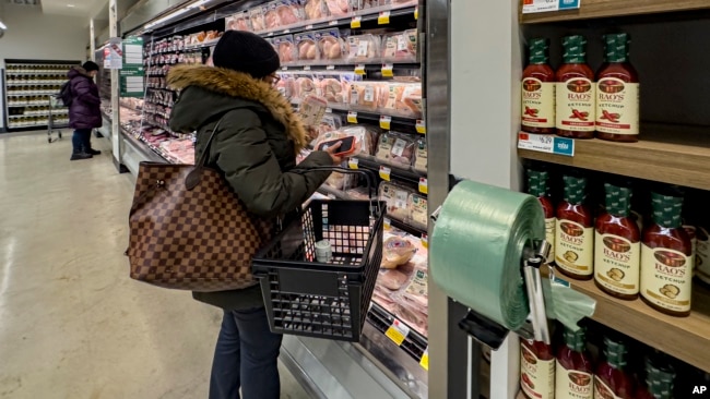 A woman studies a package of meat at a Whole Foods grocery store, Jan. 19, 2024, in New York.