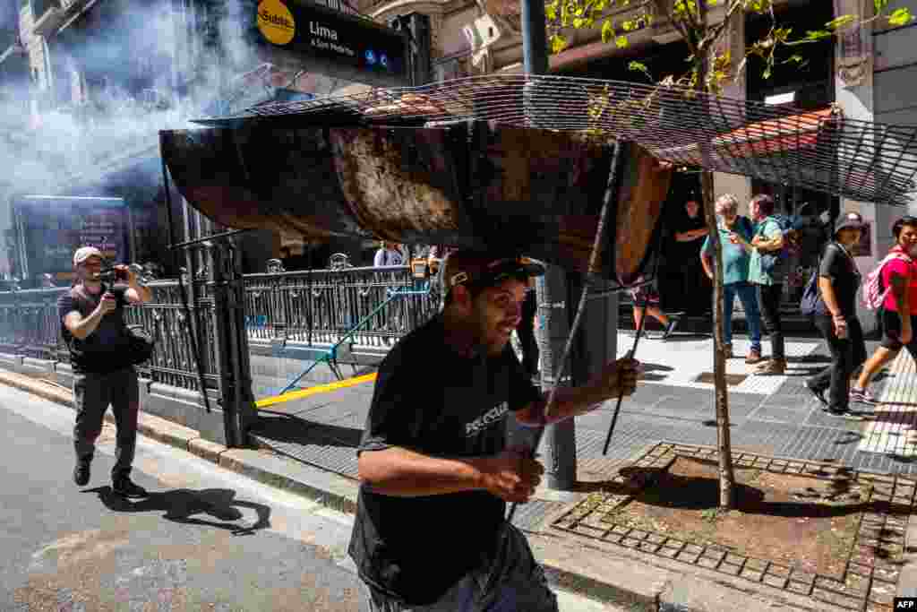 A man carrying a griller on his head takes part in a demonstration near the Argentine Congress during a national strike against the government of Javier Milei in Buenos Aires.&nbsp;&nbsp;President Javier Milei faces the first national strike in just 45 days of government against his fiscal changes and his plan to reform more than a thousand laws and regulations that governed for many years.&nbsp;