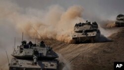 Israeli tanks head toward the Gaza Strip border in southern Israel, Oct.13, 2023.