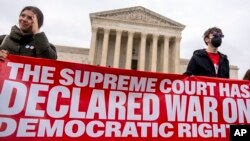 People rally in front of the Supreme Court in Washington, Dec. 7, 2022.