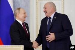 Russian President Vladimir Putin, left, and Belarus President Alexander Lukashenko shake hands during a meeting of the Union State Supreme Council in St. Petersburg, Russia, Jan. 29, 2024.