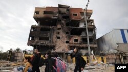 Palestinians fleeing the fighting in war-torn Gaza walk on Salaheddine road in the Zeitoun district of the southern part of the Gaza Strip, Nov. 19, 2023.