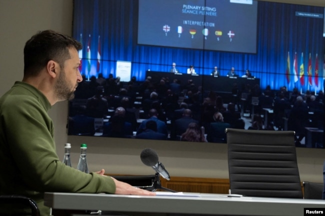 Ukrainian President Volodymyr Zelenskyy speaks via video link during the NATO Parliamentary Assembly in Copenhagen, amid Russia's attack on Ukraine, in Kyiv, Ukraine, Oct. 9, 2023. (Ukrainian Presidential Press Service/Handout via Reuters)