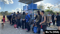 在巴拿馬聖文森(San Vicenter)移民接收點，走出雨林的中國走線移民正在排隊等巴士。 他們中不少帶著孩子一家人走線。 巴拿馬政府組織的由私人營運的大巴將把他們送往哥斯達黎加。