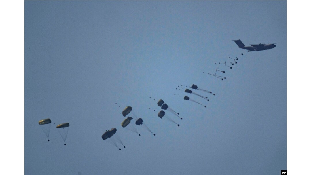 Sebuah pesawat menjatuhkan bantuan kemanusiaan ke Gaza di Jalur Gaza utara, terlihat dari Israel selatan, Jumat, 8 Maret 2024. (Foto: Leo Correa/AP Photo)