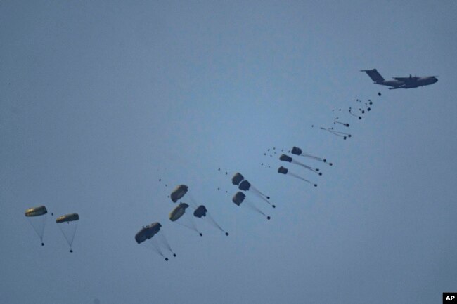 Sebuah pesawat menjatuhkan bantuan kemanusiaan ke Gaza di Jalur Gaza utara, terlihat dari Israel selatan, Jumat, 8 Maret 2024. (Foto: Leo Correa/AP Photo)